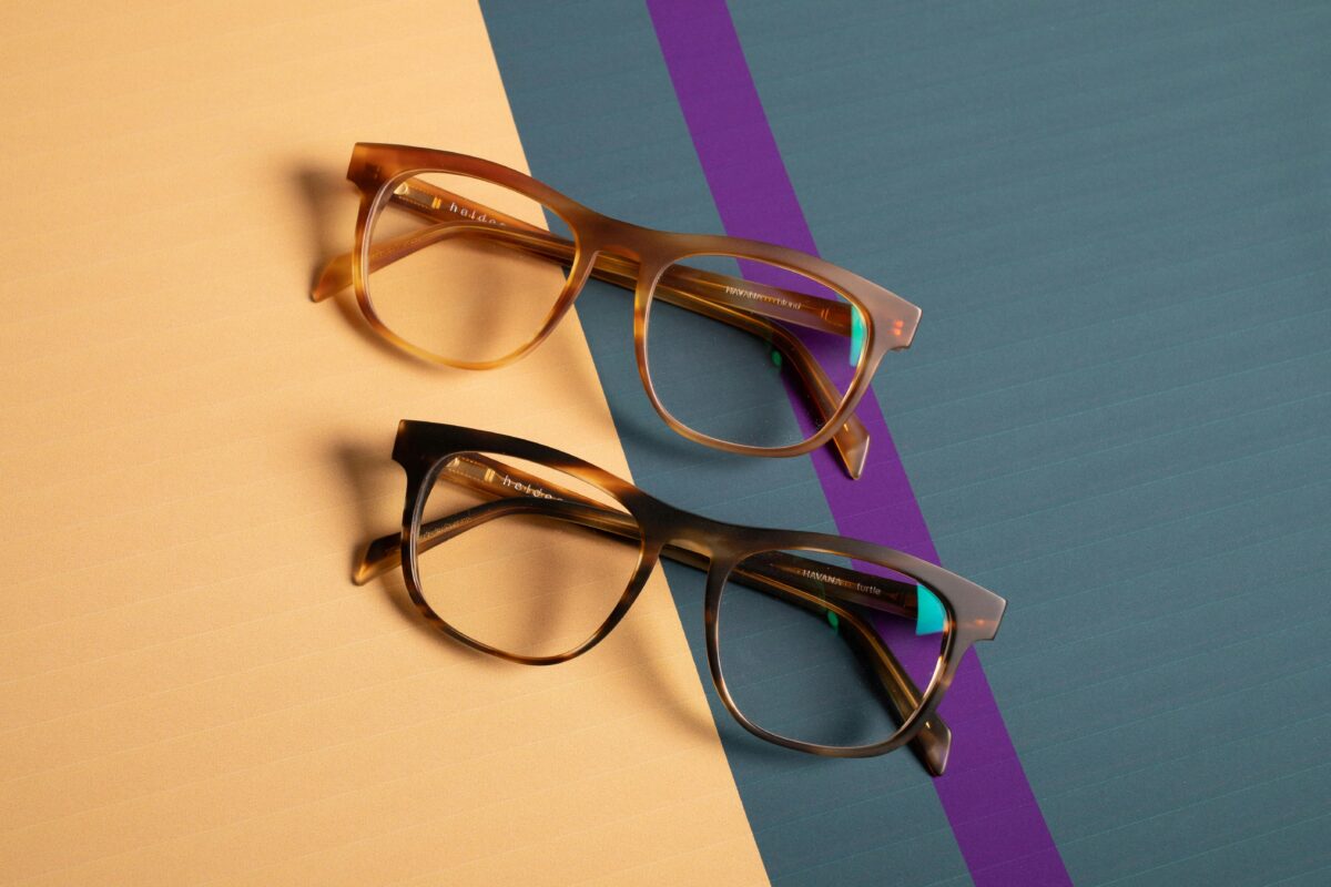 Progressive Lenses 1 Close-up of two trendy spectacles on vibrant pastel surfaces.